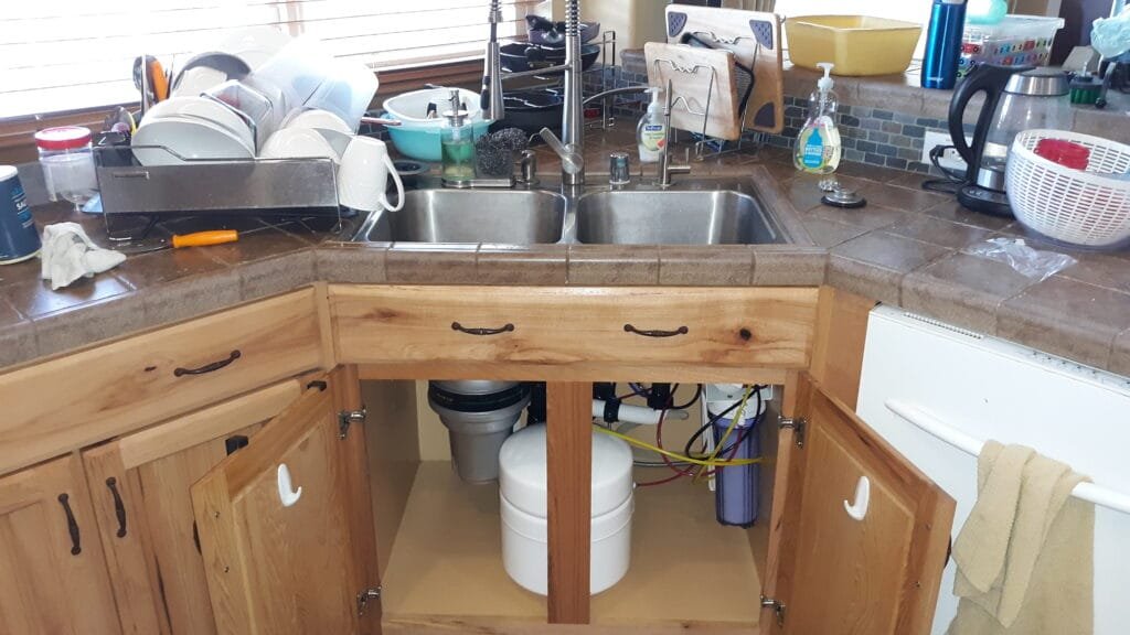 Under-sink reverse osmosis system installation in kitchen cabinet