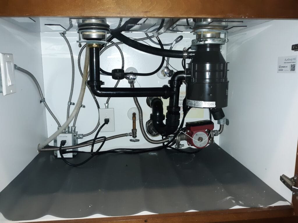 Garbage disposal and drain connections under kitchen sink