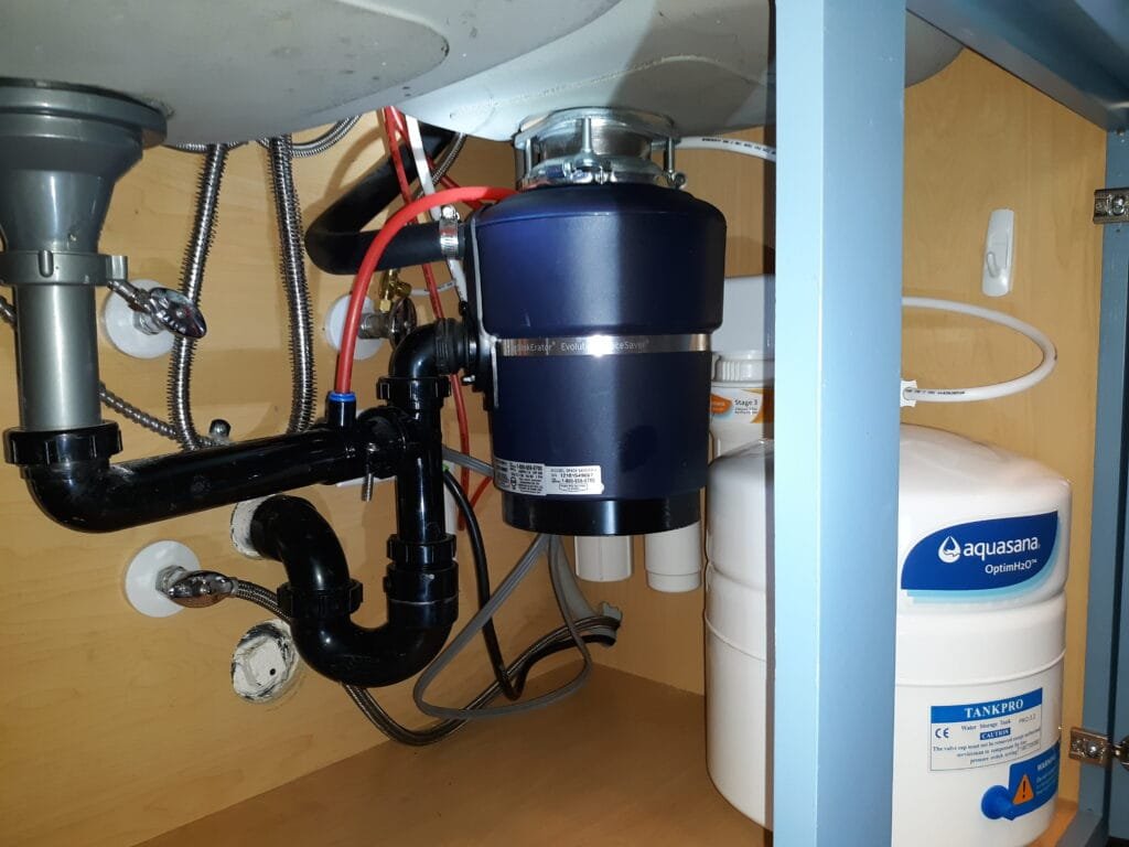 Under-sink reverse osmosis system with storage tank and plumbing connections