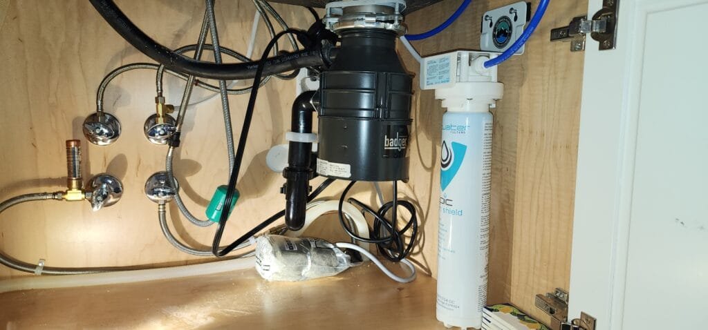 Under-sink water filtration system with plumbing connections